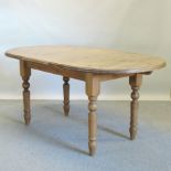 A pine oval dining table, on turned legs,