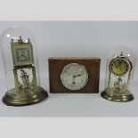 An anniversary clock, contained under a glass dome, 31cm overall, together with another smaller,