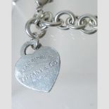 A Tiffany and Co silver bracelet with a heart shaped pendant,