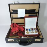 A case containing four medals, a badge and various regalia,