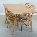 An Ercol light elm rectangular dining table, together with a set of four spindle back dining chairs,
