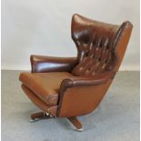 A 1970's style brown upholstered button back swivel arm chair,