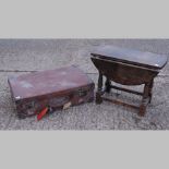A leather suitcase, together with an oak drop leaf occasional table,