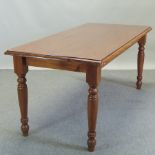 A stained pine dining table, on turned legs,