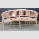 A teak curved garden bench,