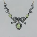 An early 20th century peridot and diamond necklace, of tied ribbon and bow design,