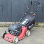 A red Sovereign petrol rotary lawn mower,
