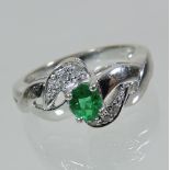 An 18 carat white gold emerald and diamond ring,