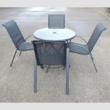 A modern circular glass top garden table, 88cm,