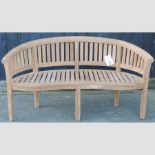 A teak curved slatted wooden garden bench,