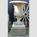 A 19th century carved marble campana shaped urn, on a stone base,