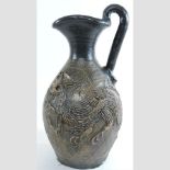 A glazed terracotta ewer, with relief decoration,