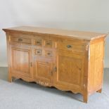 A pine sideboard, with an arrangement of drawers and cupboards,