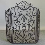 An iron open work three fold fire screen,