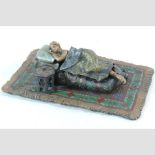 A reproduction cold painted bronze figure of a lady, reclining in bed,