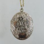 An engraved locket, of hinged oval shape,