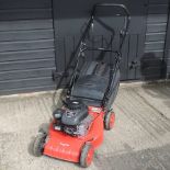 A red Champion petrol lawn mower