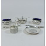 A silver three piece condiment set, together with a napkin ring, sugar tongs,