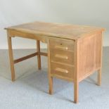 An early 20th century light oak desk,