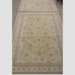 A pair of modern woollen carpets each with floral designs on a cream ground,