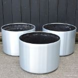 A set of three brushed aluminium garden pots,