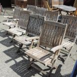 A set of eight teak slatted folding garden chairs,