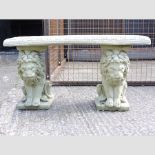 A reconstituted stone bench, with lion end supports,