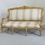 A French style gilt painted carved and silk upholstered sofa,