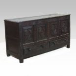 An 18th century carved oak mule chest, with a hinged lid and panelled front,