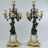 A pair of continental bronze and gilt metal mounted five branch candelabra,