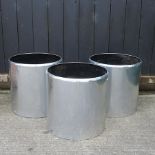 A set of three polished aluminium garden pots,