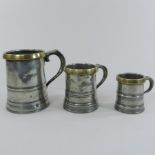 A set of three Edward VII brass mounted pewter graduated mugs, comprising a quart,