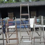 A collection of five various wooden stepladders