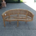 A teak curved slatted garden bench,