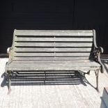 A slatted wooden garden bench, with cast iron ends,