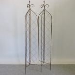 A pair of metal lattice garden spires,