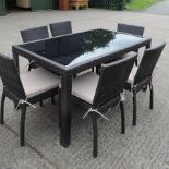 A contemporary rattan and glass top garden table, 151 x 91cm,