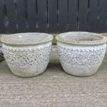 A pair of reconstituted stone circular planters, with relief decoration,