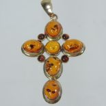 An amber cabochon cross shaped pendant