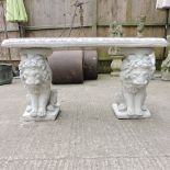 A reconstituted stone bench, on lion supports,