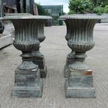 A set of four cast iron urns, on plinth bases,