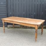 A pine kitchen table, on turned legs,