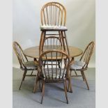 An Ercol elm drop leaf dining table, together with six spindle back chairs,
