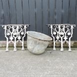 A pair of ornate wrought iron table ends together with another pair, and a cast iron bowl,
