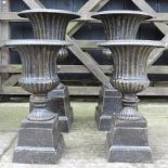 A pair of large iron urns, 67cm tall,