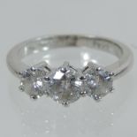An 18 carat white gold three stone diamond ring, approximately one carat,