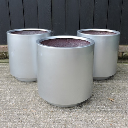 A set of three silver coloured garden planters,