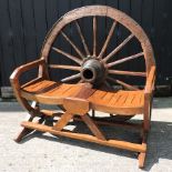 A teak cartwheel back garden bench,