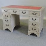 A painted pedestal desk, on a plinth base, with a red leather top,