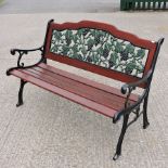 A green painted metal and slatted garden bench, with grapes and vine panel,